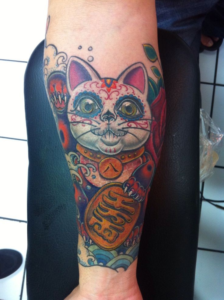 Mexican style colored forearm tattoo of maneki neko japanese lucky cat with golden tablet