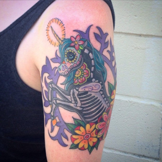 Mexican style unicorn with skeleton elements framed shoulder colored tattoo with flowers