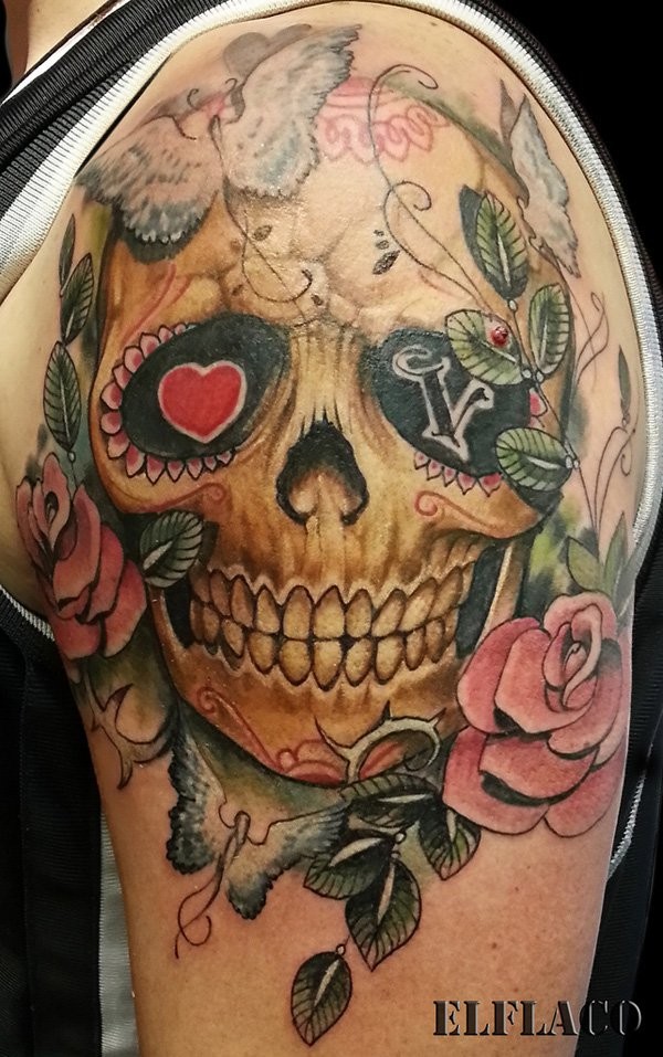 Mexican traditional shoulder tattoo of human skull stylized with flowers and butterflies