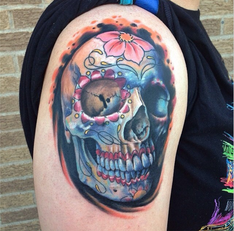 Mexican traditional style colored shoulder tattoo of human skull with flowers