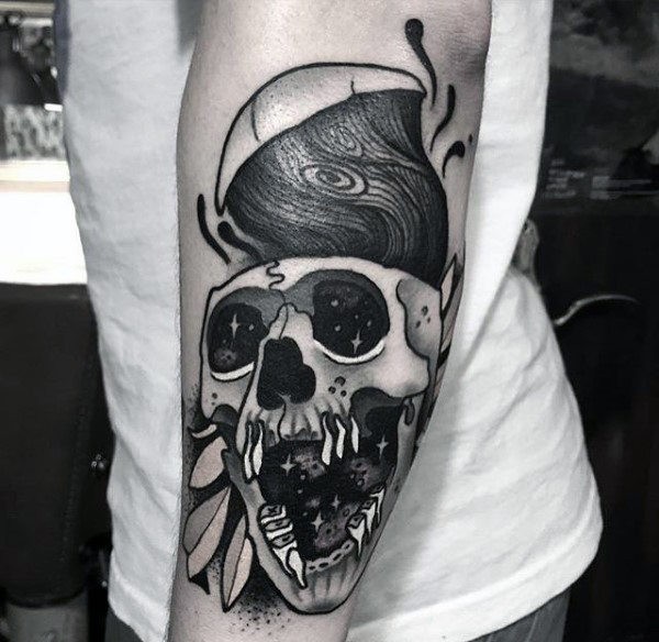 Modern style colored black ink arm tattoo of corrupted human skull with leaves