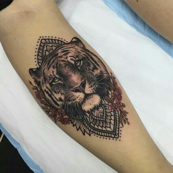 Modern style colored leg tattoo of tiger head with flowers