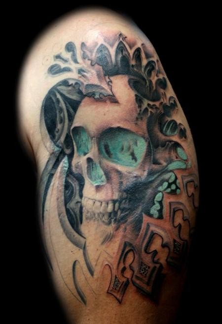 Modern style colored shoulder tattoo of human skull with ornaments