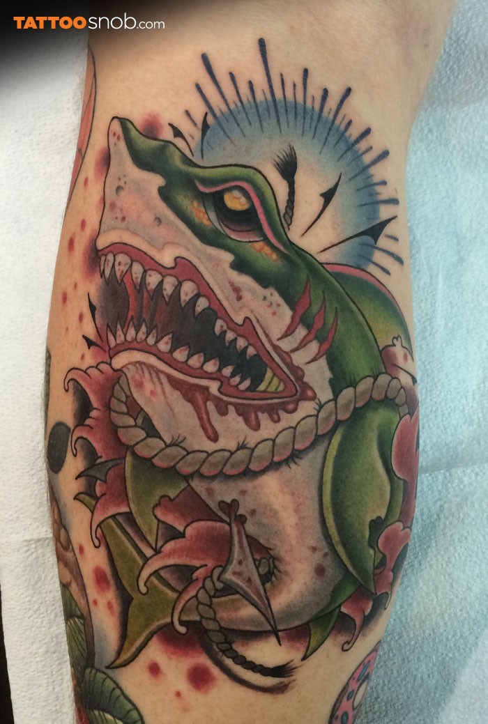 Modern traditional style bloody leg tattoo of creepy shark with rope