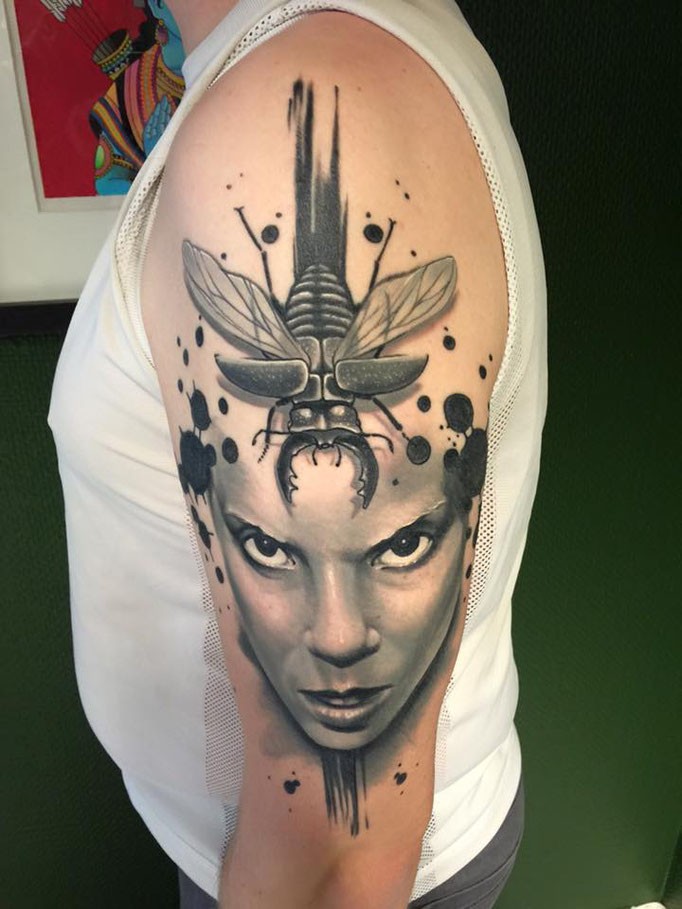Modern traditional style detailed shoulder tattoo of woman face with big bug
