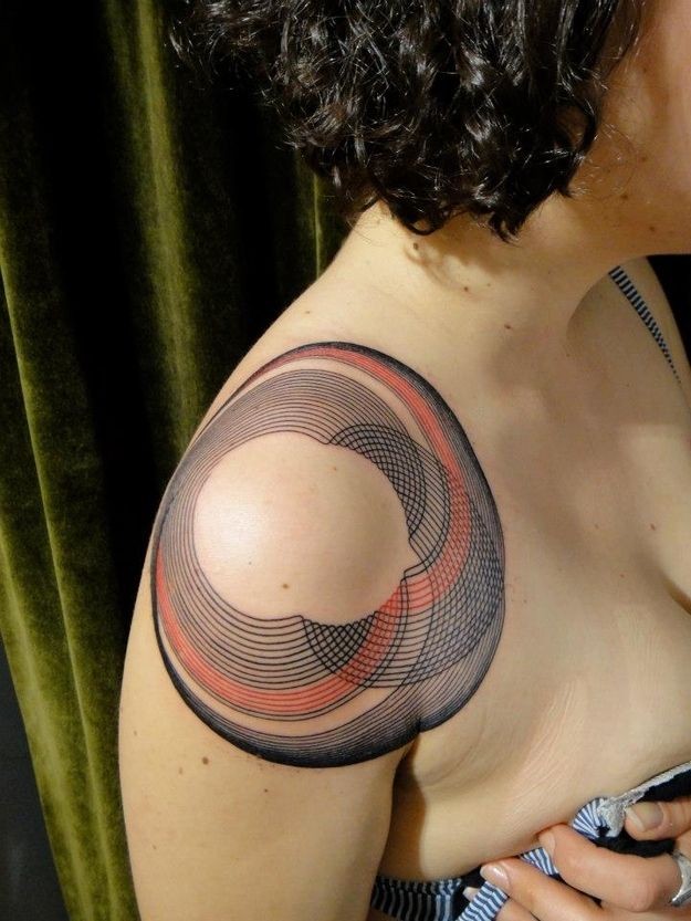 Tatuaje en el hombro, círculos geométricos de colores negro y rojo