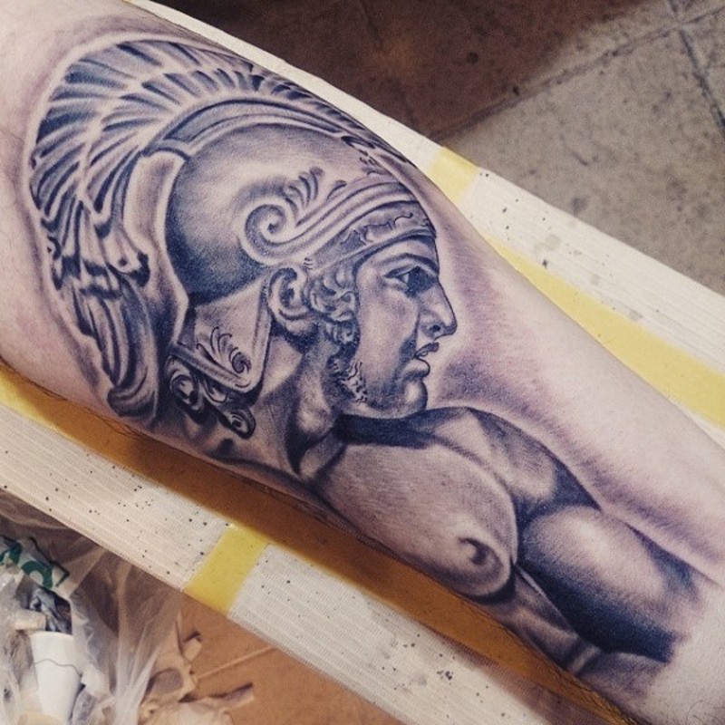 Muscular Spartan warrior in helm pale colored detailed tattoo