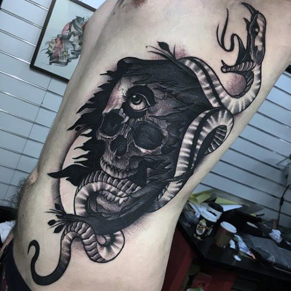 Mysterious black ink human skull with eye tattoo on side combined with snake