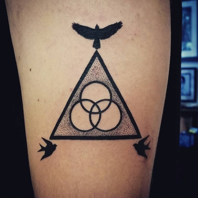 Mysterious black ink shoulder tattoo of triangle stylized with circles and birds