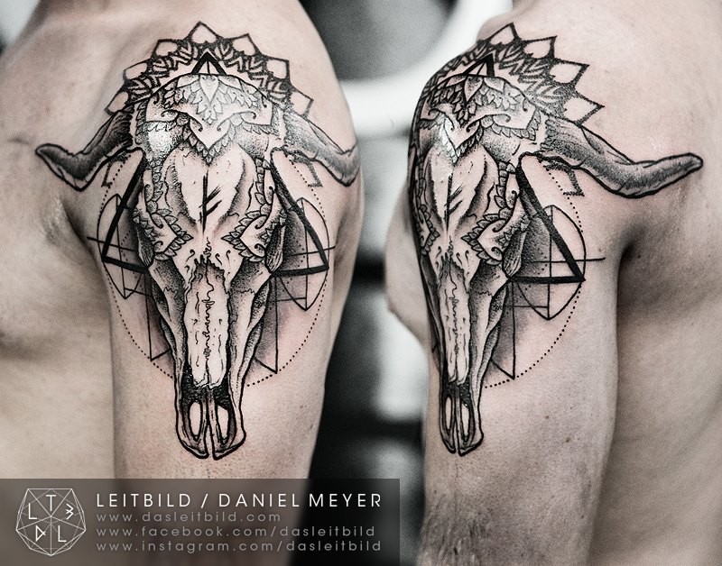Mysterious black ink shoulder tattoo of large animal skull with geometrical ornaments