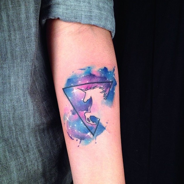 Mysteriöses mehrfarbiges Dreieck Raum Tattoo am Unterarm mit Einhorns Silhouette