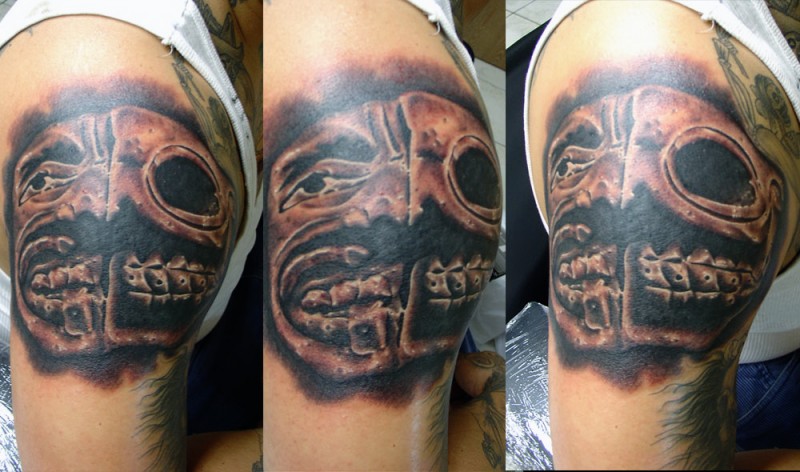 Mystic colored shoulder tattoo of creepy looking face