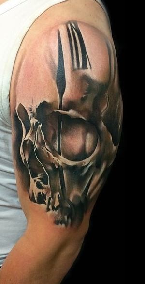 Mystical black and white human skull tattoo on shoulder stylized with clock