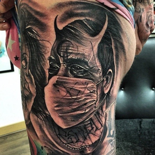 Mystical black ink thigh tattoo of man with mystic symbol