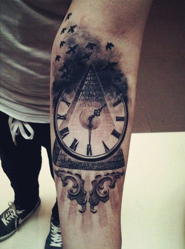 Tatuaje en el antebrazo, pirámide con reloj y bandada de aves