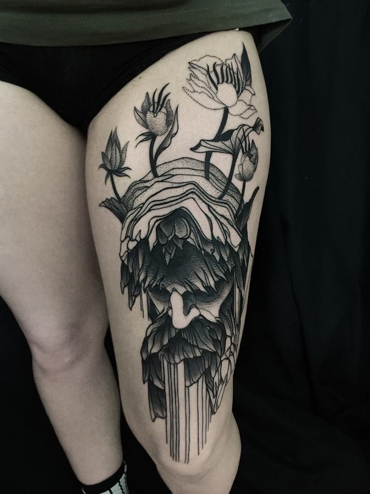 Mistico stile blackwork disegnato da Michele Zingales coscia il tatuaggio della vecchia testa con i fiori