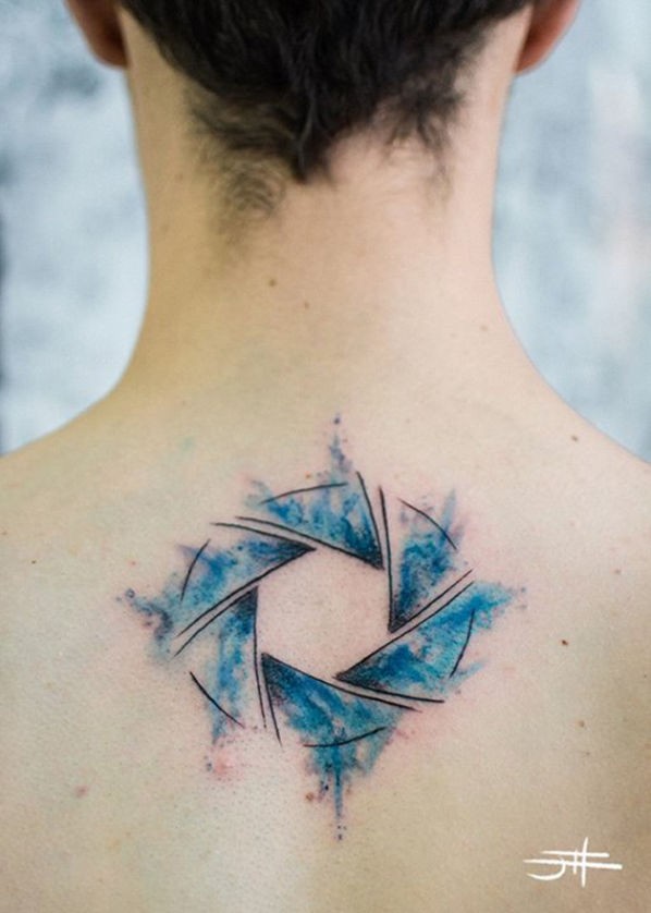 Mystical colored upper back tattoo of circle shaped symbol