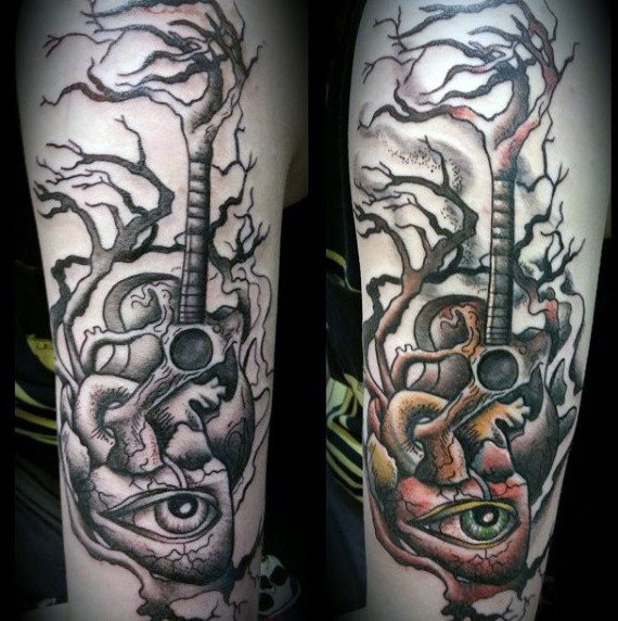 Tatuaje en el brazo,
 guitarra con corazón humano con ojo espantoso