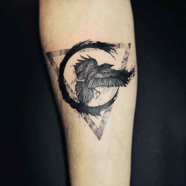 Tatuaje en el antebrazo, cuervo con triángulo y círculo, tinta negra