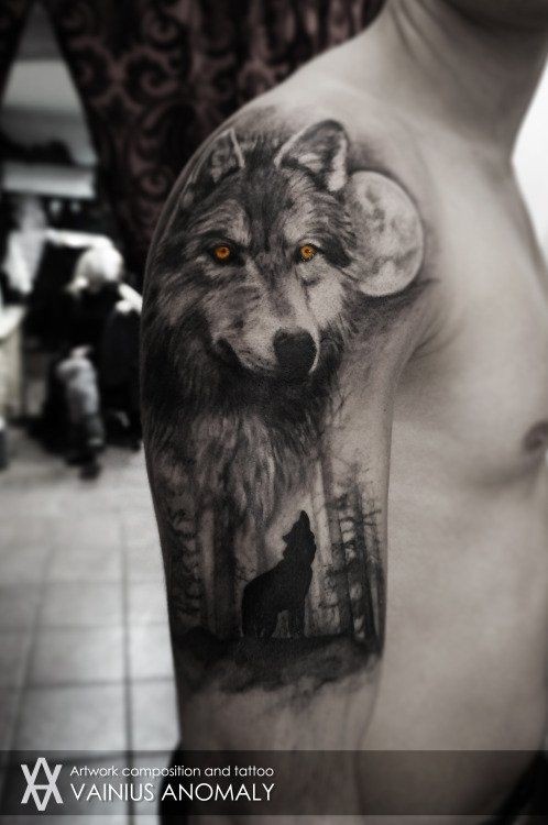 Mystical looking colored upper arm tattoo of wolf in forest with yellow eyes