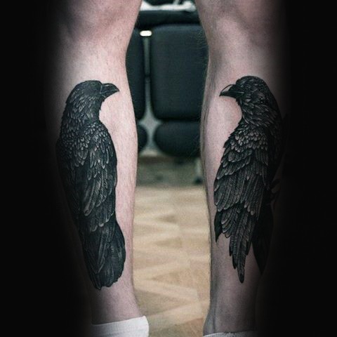 Mystical pair of dark black crows detailed natural looking tattoo on both legs under knees