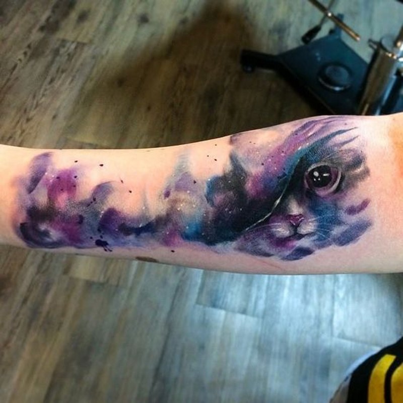 Mystical space like colored tattoo with cat on arm