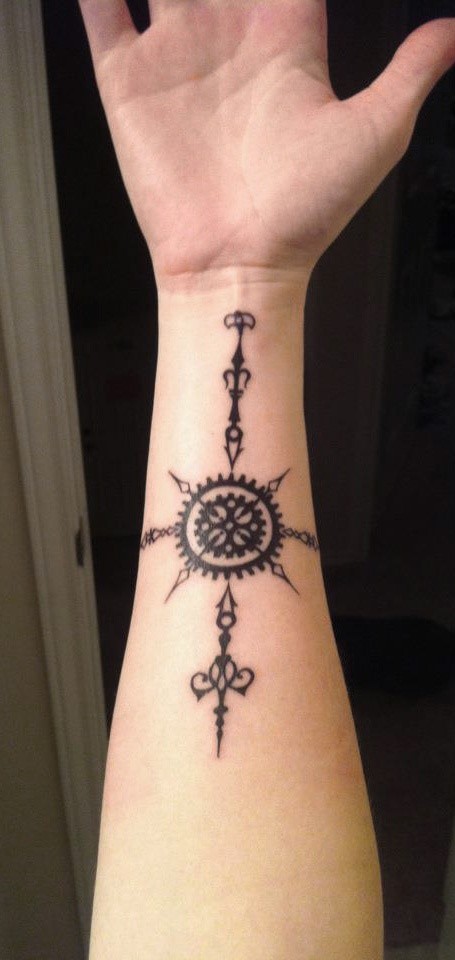 Mystical tribal style black ink sun shaped tattoo on arm