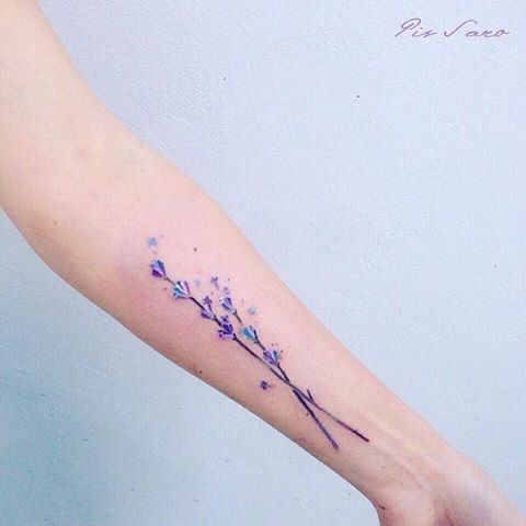 Natural colored small beautiful flowers tattoo on forearm