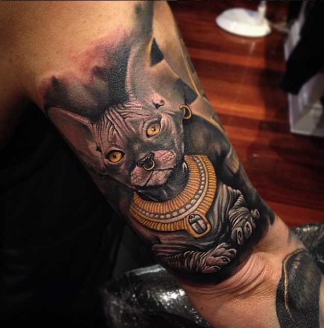 Tatuaje en el brazo, gato egipcio divino muy realista con collar precioso