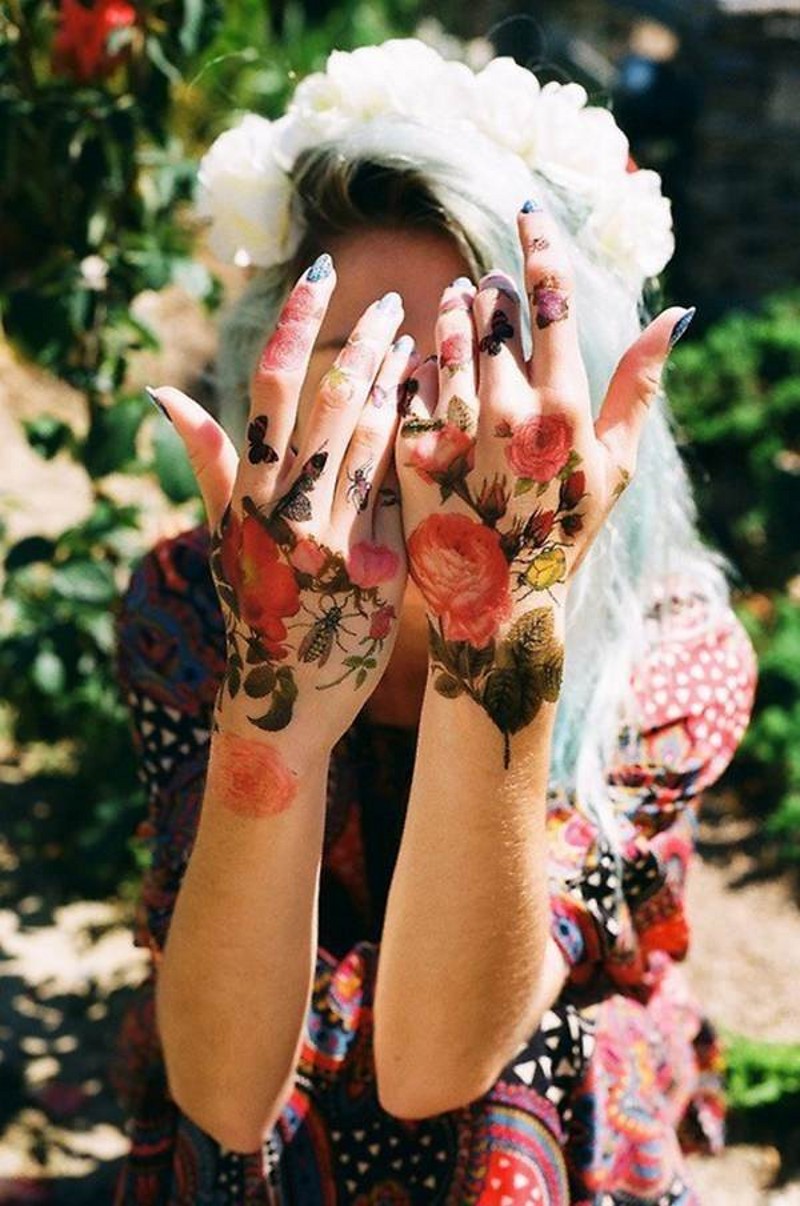 Natürlich aussehendes großes mehrfarbiges Tattoo von verschiedenen Blumen und Käfern Händen und Fingern