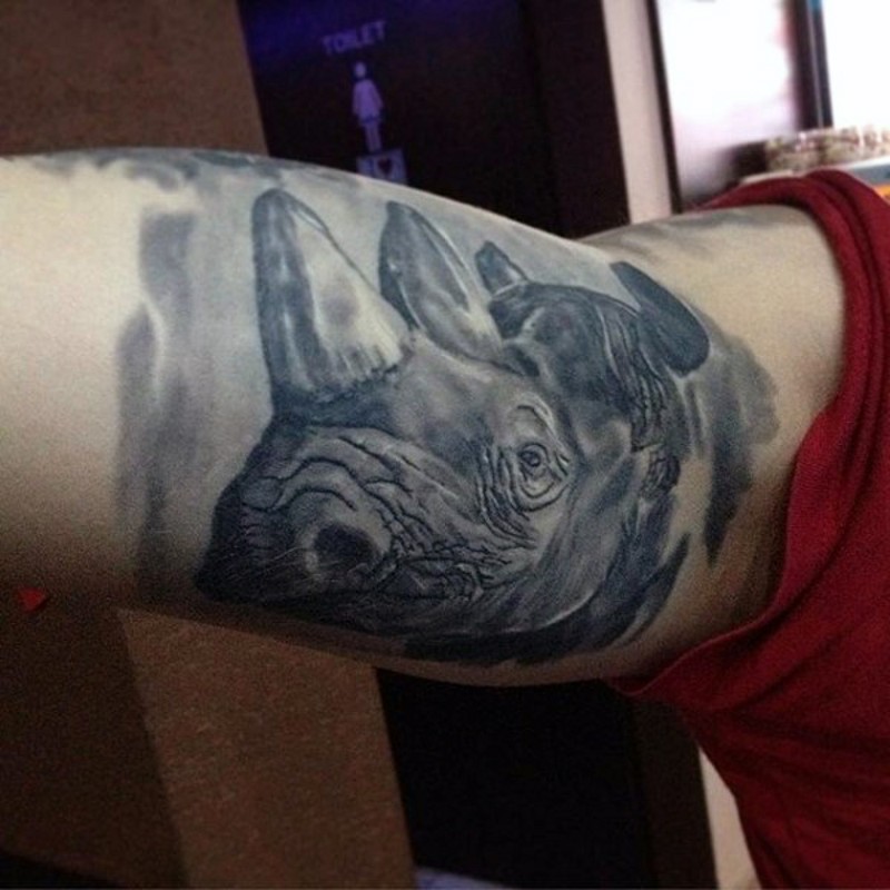 Natural looking black and white biceps tattoo of rhino head