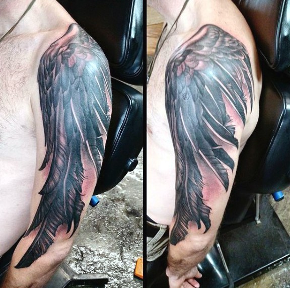 Natural looking black and white crow wing tattoo on shoulder