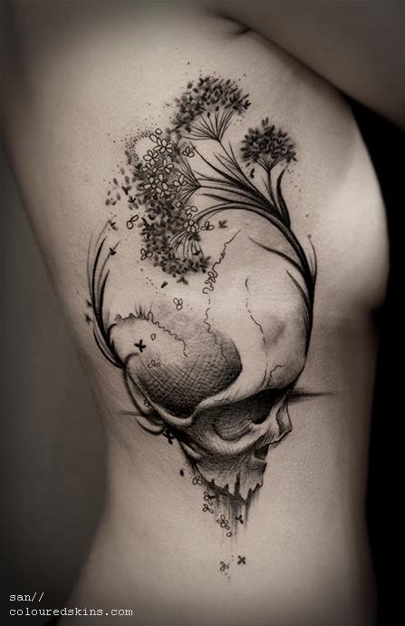 Natürlich aussehender schwarzer und weißer menschlicher Schädel Tattoo an der Seite mit wilden Blumen