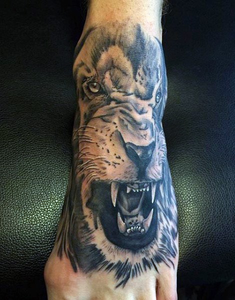Natural looking black and white roaring lion tattoo on foot