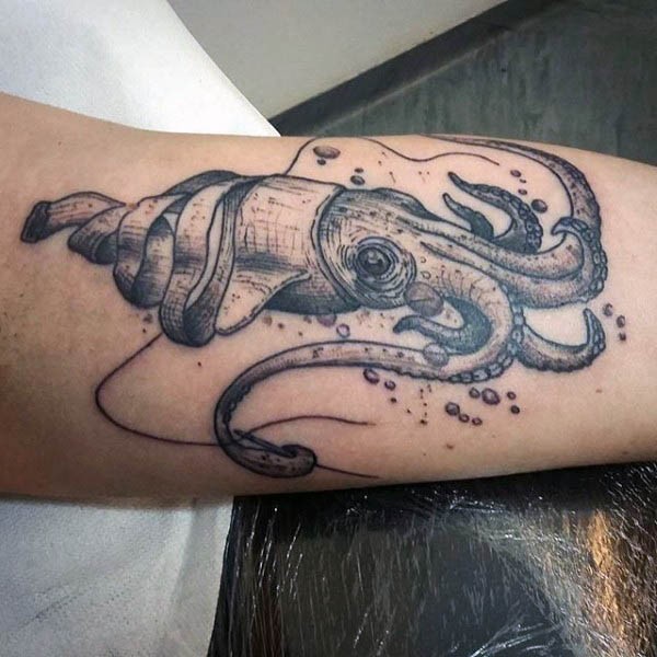 Natural looking black ink little squid tattoo on arm