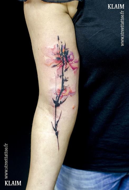 Natural looking colored arm tattoo of big flower