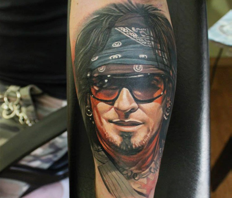 Natural looking colored arm tattoo of cool looking rock player