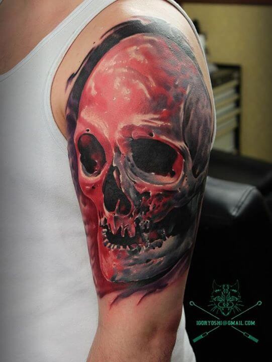Natural looking colored big skull tattoo on shoulder