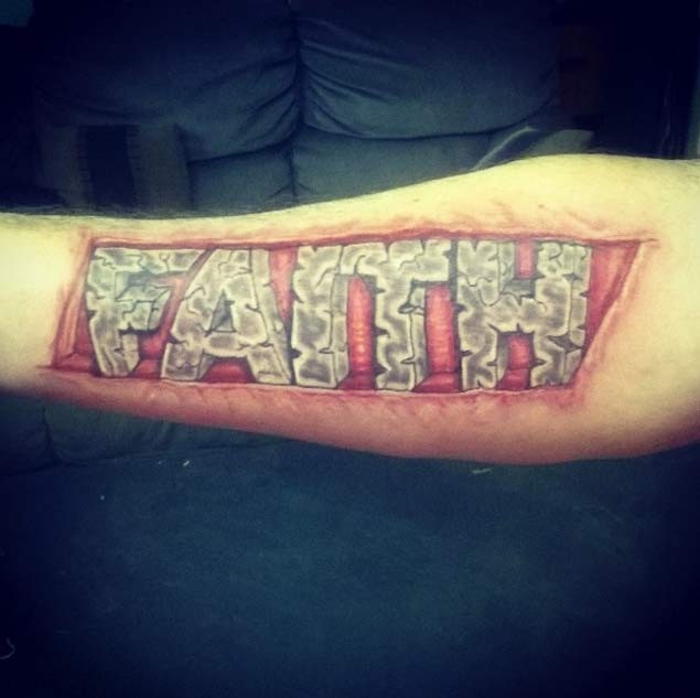 Natürlich aussehendes farbiges Unterarm Tattoo mit Wort aus Stein  &quotFaith"
