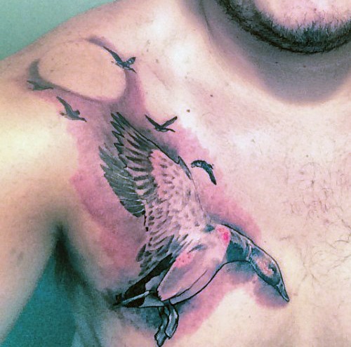 Natural looking colored illustrative style chest tattoo of flying ducks