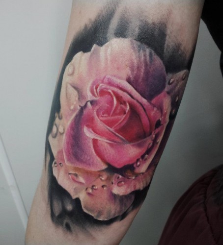 Natural looking colored rose tattoo on arm