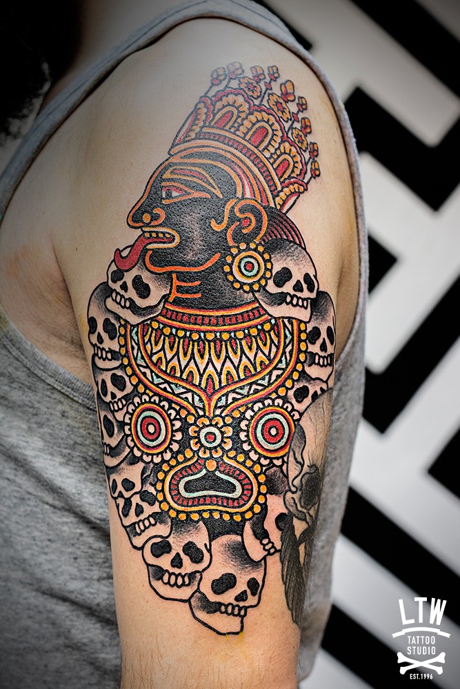 Natural looking colored shoulder tattoo of Hinduism God with skulls