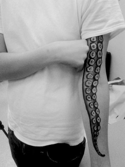 Natural looking detailed black and white octopus tentacle tattoo on sleeve
