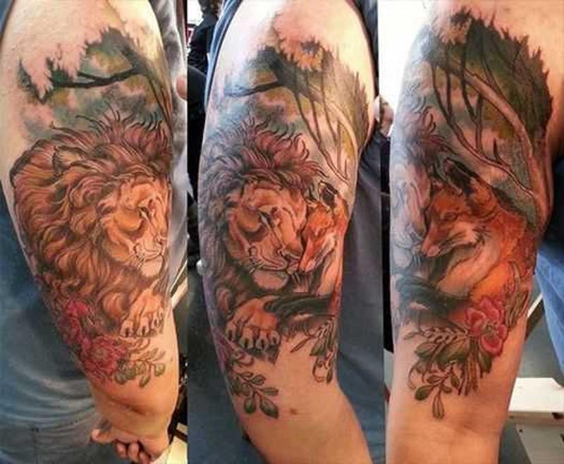 Natural looking funny sleeping lion and fox tattoo on shoulder combined with flowers and trees
