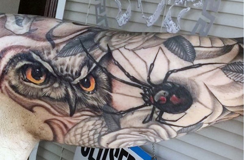 Natural looking real photo like colored owl with spider tattoo on sleeve