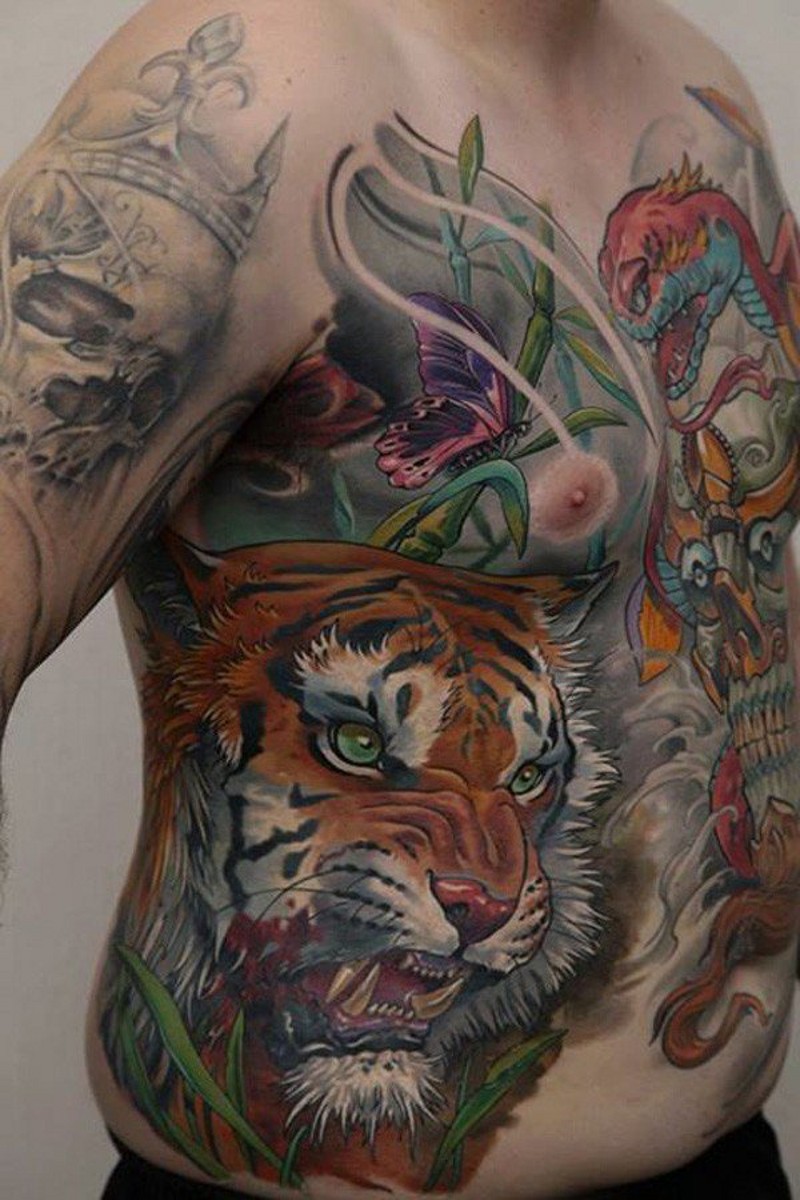 Natural looking very beautiful colored angry tiger tattoo on chest combined with butterfly and snake