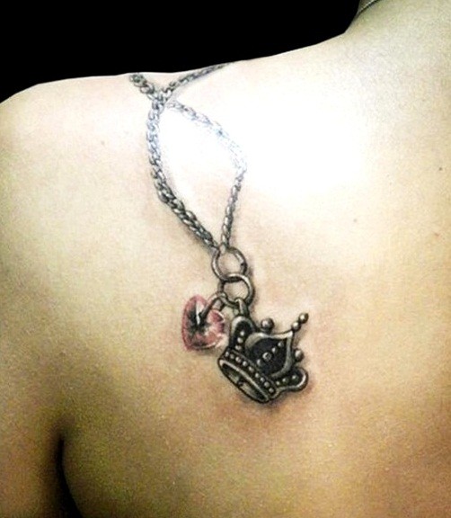 corona e cuore sulla catena tatuaggio sulla scapola