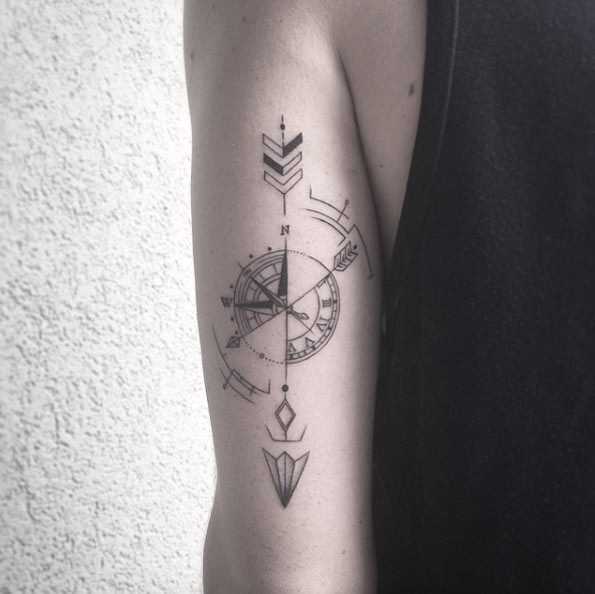 Nautical style black ink upper arm tattoo of arrow with compass