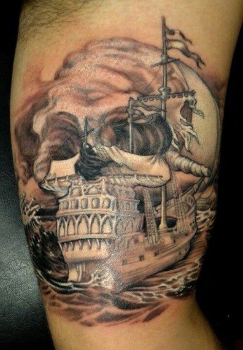 Nautical themed colored big ship with skull tattoo on arm
