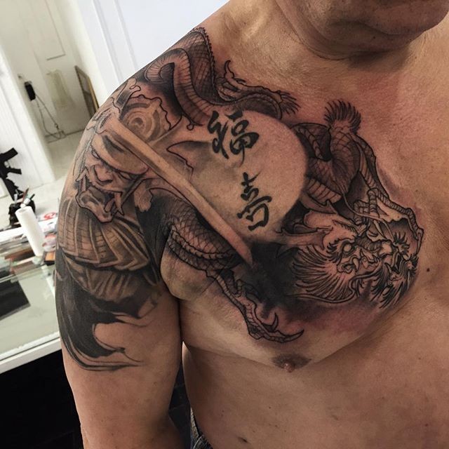 Neo japanese style black ink shoulder and chest tattoo of fantasy dragon and lettering